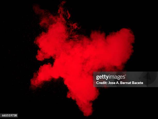 explosion of a cloud of powder of particles of  color red on a black background - conceptos 個照片及圖片檔