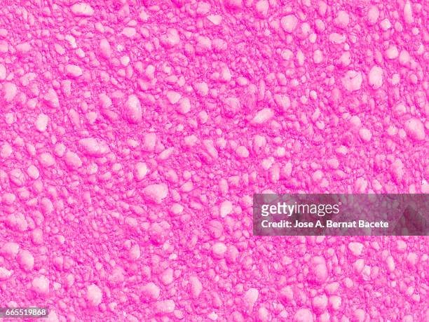 full frame of coarse and wavy textures of colored foam, pink background - agujero stockfoto's en -beelden