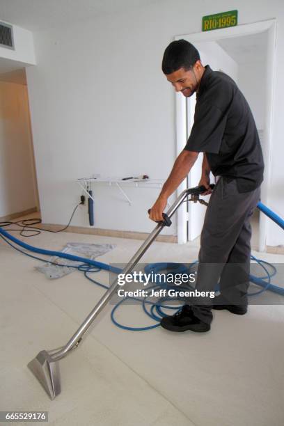 Carpet cleaner vacuuming the floor.