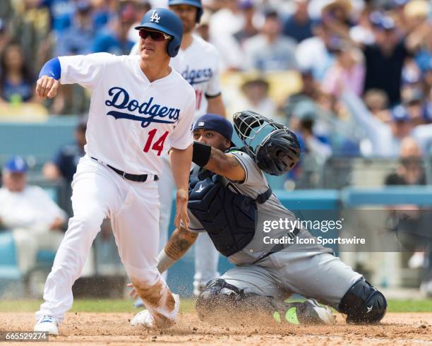 Los Angeles Dodgers left fielder Enrique Hernandez slides safely onto home plate before being tagged by San Diego Padres catcher Hector Sanchez...