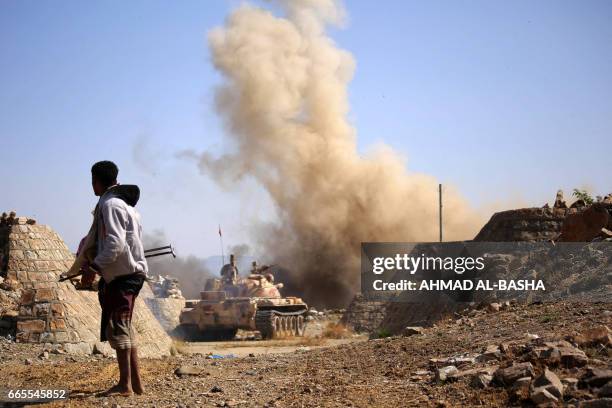 Yemeni fighter loyal to Yemen's exiled President Abedrabbo Mansour Hadi, fires from a tank during clashes with Shiite Huthi rebels in the country's...