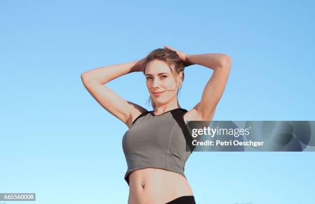 fit young woman in exercise clothing looking at the camera. - tight ponytail stock pictures, royalty-free photos & images