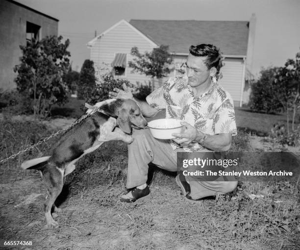 Carmen Basilio spends some quality time with his dog while training in Alexandria Bay New York, 1957.