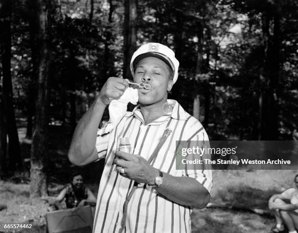 Archie Moore blowing bubbles at this training camp in North Adams, Massachusetts, circa 1956.