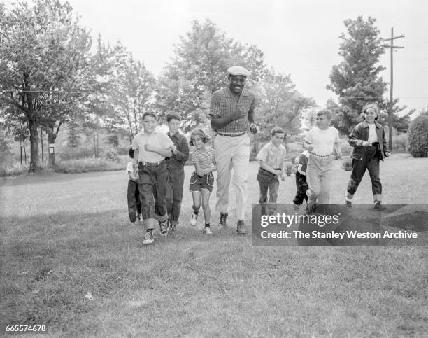 Ezzard Charles taking a jog with some young fans while he is preparing for his title fight with Rocky Marciano at Kutsher's Resort in Monticello, New...
