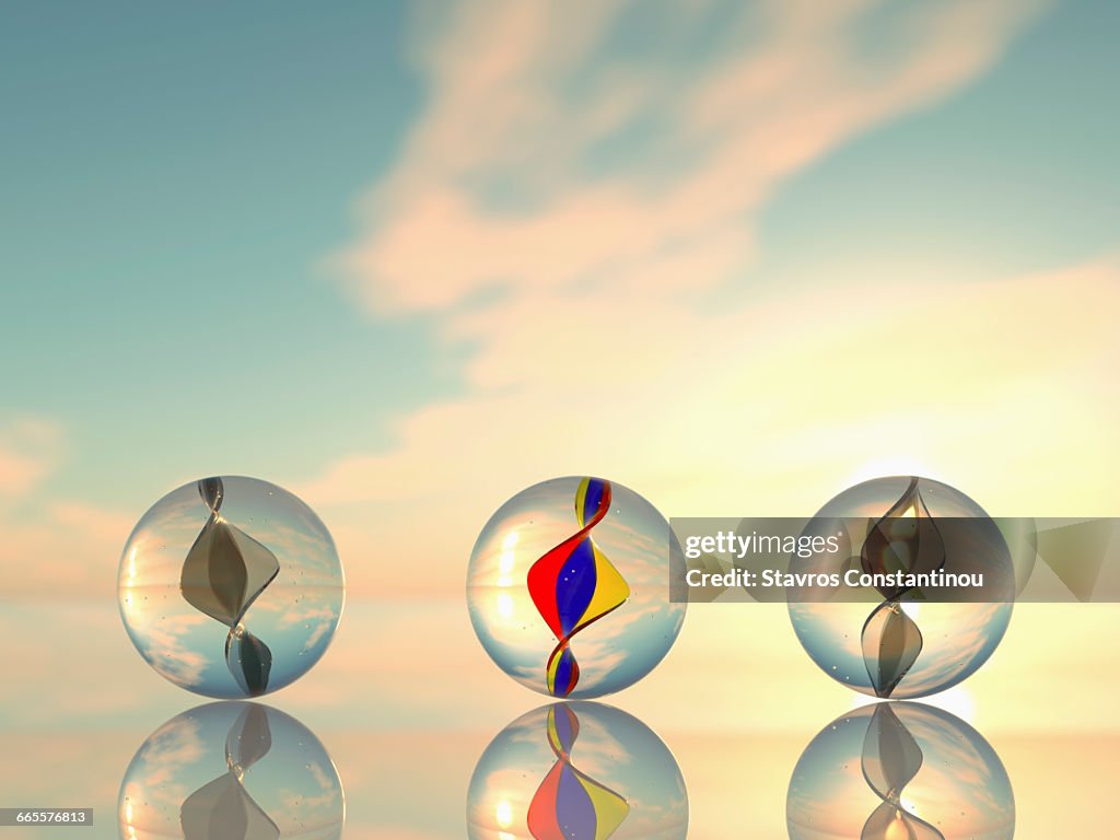 Three marbles on a reflective surface