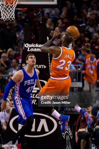 Tiago Splitter of the Philadelphia 76ers attempts to block LeBron James of the Cleveland Cavaliers during the first half at Quicken Loans Arena on...