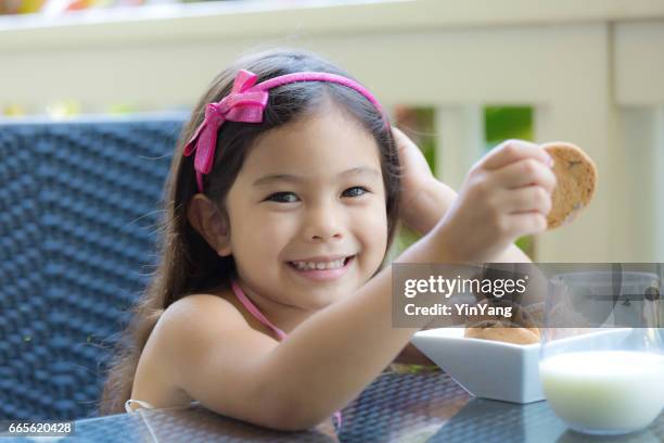 young girl hawaiian polynesian children with cookies and milk - hawaiian print dress stock pictures, royalty-free photos & images