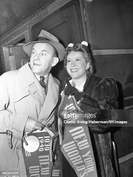 Portrait of married American comedy and acting duo George Burns and Gracie Allen as they pose with pennants from the New York World's Fair, New York,...