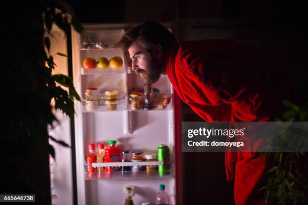 handsome bearded man in front of the refrigerator during the night - robe 2017 stock pictures, royalty-free photos & images