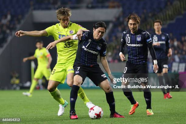 Yasuhito Endo of Gamba Osaka controls the ball under pressure of Tsukasa Shiotani of Sanfrecce Hiroshima during the J.League J1 match between Gamba...