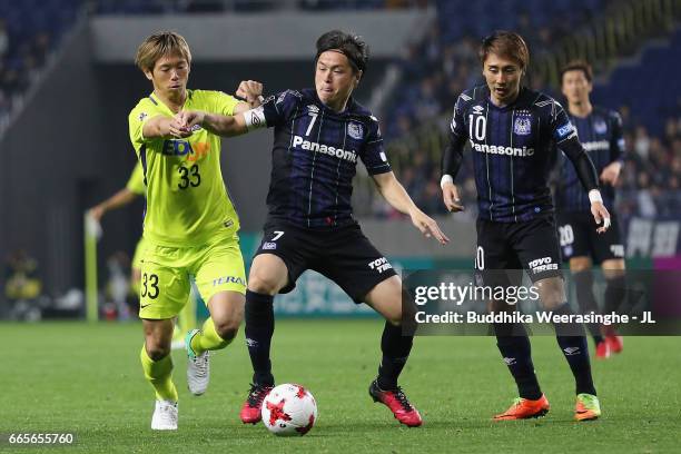 Yasuhito Endo of Gamba Osaka controls the ball under pressure of Tsukasa Shiotani of Sanfrecce Hiroshima during the J.League J1 match between Gamba...