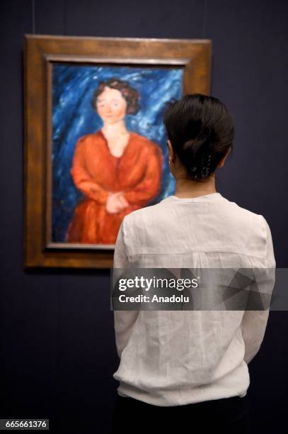 Gallery assistant poses with Chaim Soutine La Femme en rouge au fond bleu, 1928 at the London press view of Impressionist, Modern and Contemporary...