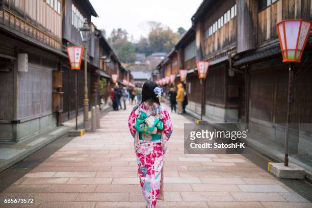 young woman walking ing traditional japanese shopping street - kanazawa stock pictures, royalty-free photos & images