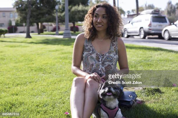 woman sitting in park with dog - scott zdon fotografías e imágenes de stock