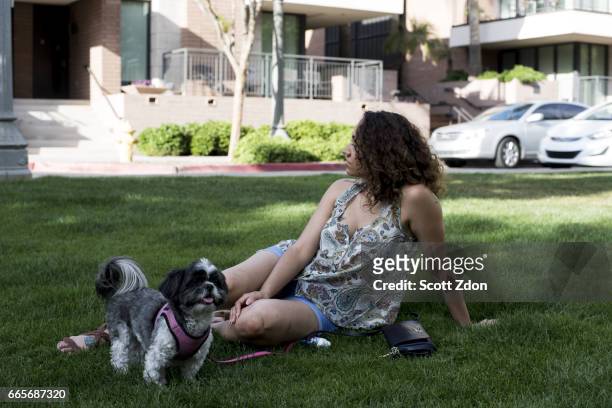 woman sitting in park with dog - scott zdon foto e immagini stock