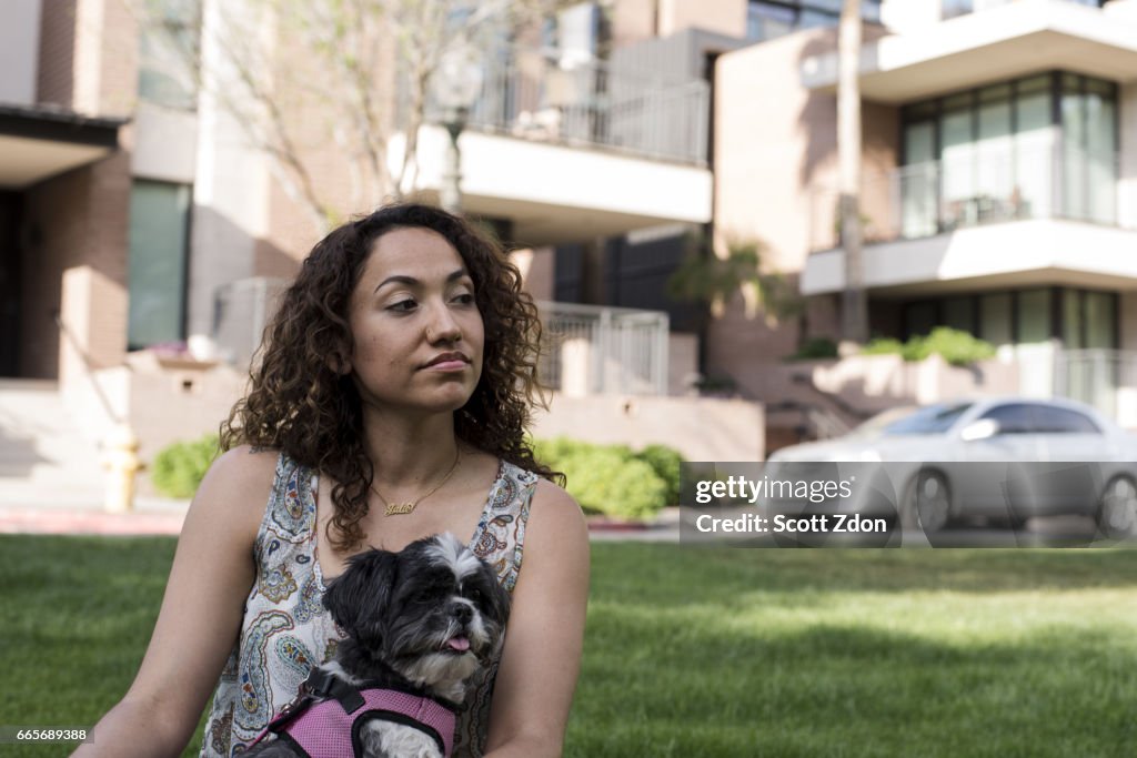 Woman sitting in park with dog on her lap