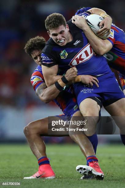 Adam Elliott of the Bulldogs is tackled by the Knights defence during the round six NRL match between the Newcastle Knights and the Canterbury...