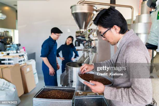 team of coffee roasters working in their workshop - coffee manufacturing stock pictures, royalty-free photos & images
