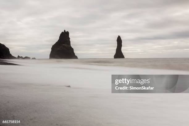 basalt sea stracks on shore at beach - vik stock pictures, royalty-free photos & images