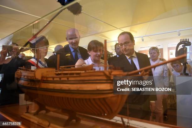 French President Francois Hollande looks at a galley as he visits the Negritude house on April 7, 2017 in Champagney, eastern France. / AFP PHOTO /...