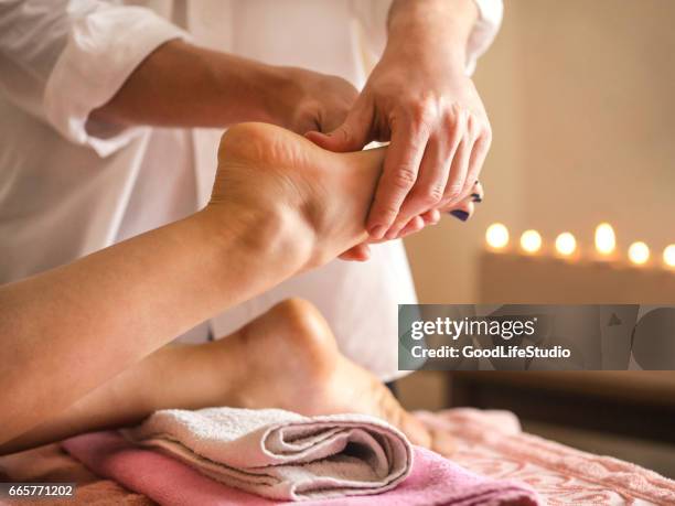 foot massage - woman lying on stomach with feet up stock pictures, royalty-free photos & images