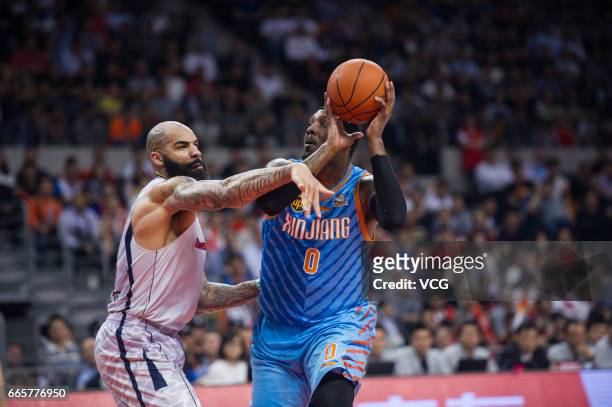 Andray Blatche of Xinjiang Flying Tigers drives the ball against Carlos Boozer of Guangdong Southern Tigers in Game Four of the 2017 CBA Finals at...