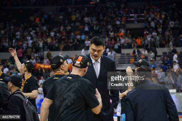 Former NBA star Yao Ming delivers the trophy to players of Xinjiang Flying Tigers during the celebration ceremony after Game Four of the 2017 CBA...