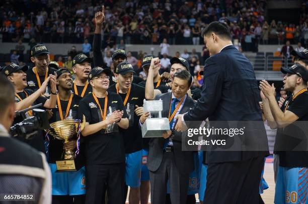 Former NBA star Yao Ming delivers the trophy to players of Xinjiang Flying Tigers during the celebration ceremony after Game Four of the 2017 CBA...