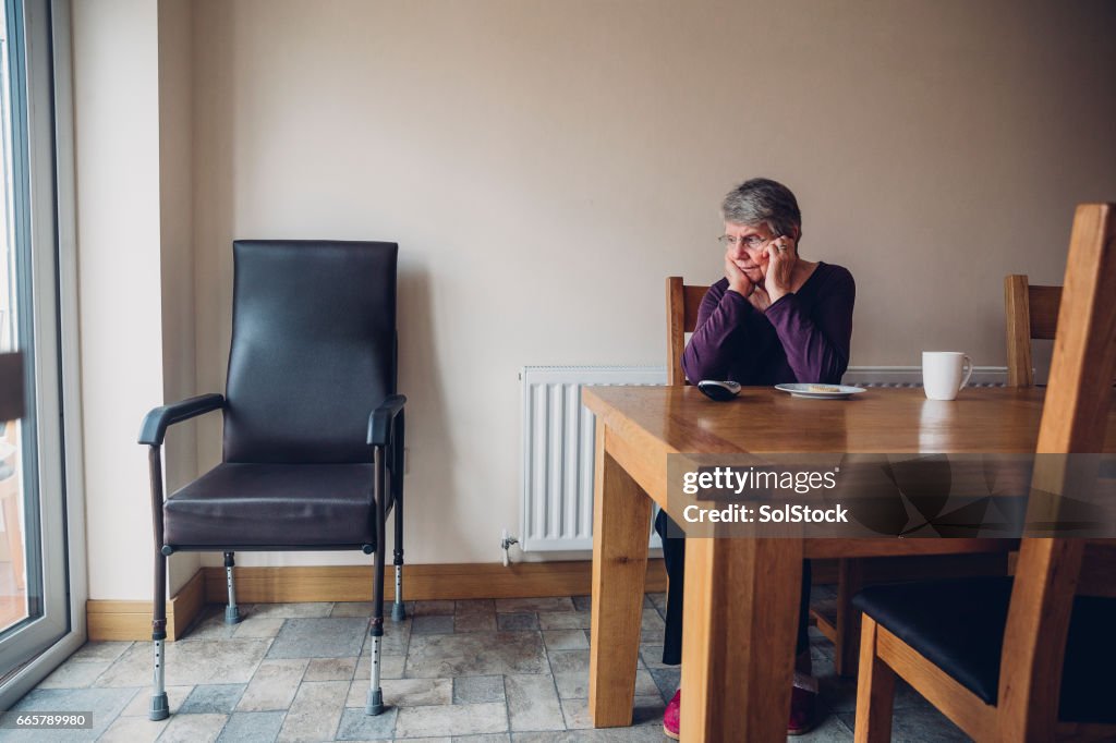 Senior Woman Sitting Beside an Empty Chair