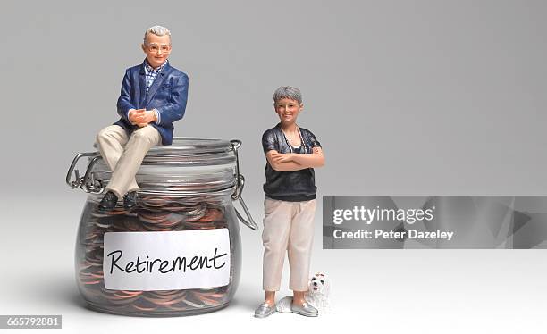 retired couple with retirement savings jar - retirement savings stock pictures, royalty-free photos & images