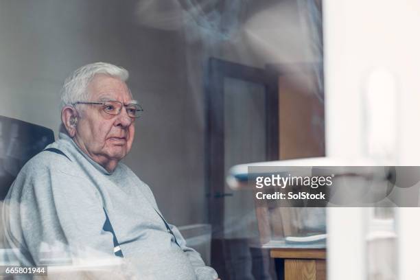 senior man seen through a window - fat people stock pictures, royalty-free photos & images