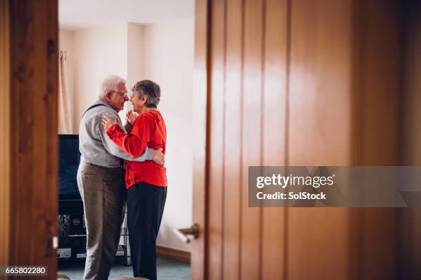 senior tenderness as they dance in their home - couple candid stock pictures, royalty-free photos & images