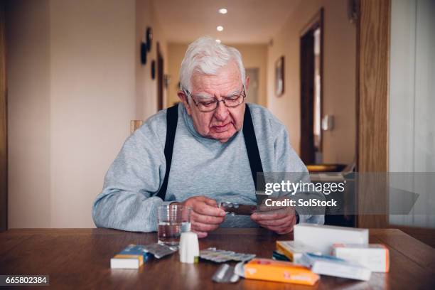 elderly man with all his medication - chronic illness stock pictures, royalty-free photos & images