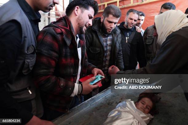 The father of one-year-old infant Amira grieves over her body as it lies in a make-shift morgue, after she died in a reported air strike on the...