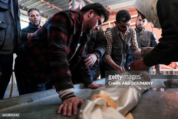 The father of one-year-old infant Amira grieves over her body as it lies in a make-shift morgue, after she died in a reported air strike on the...