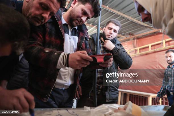 Syrian takes one last picture of his daughter, one-year-old infant Amira, whose body lies in a make-shift morgue, after she died in a reported air...