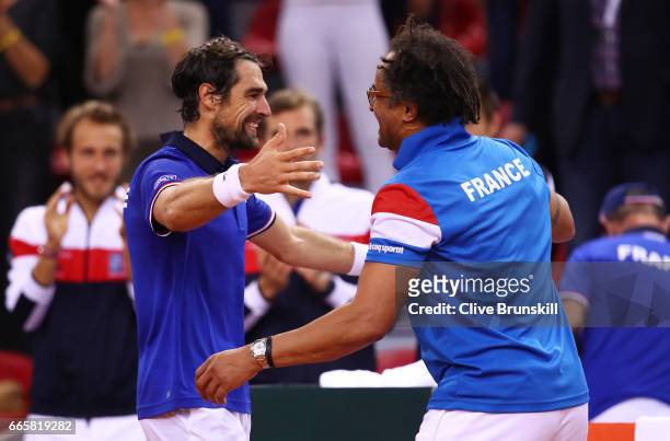 Jeremy Chardy of France celebrates with Yannick Noah the France captain following his victory during the singles match against Daniel Evans of Great...