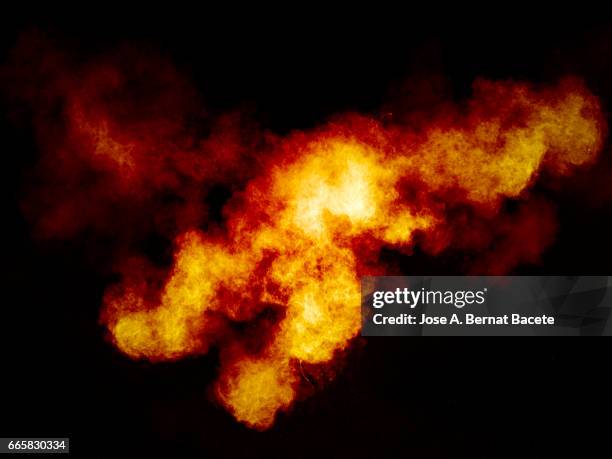 explosion of a cloud of powder of particles of  colors yellow and orange on a black background - explotar photos et images de collection