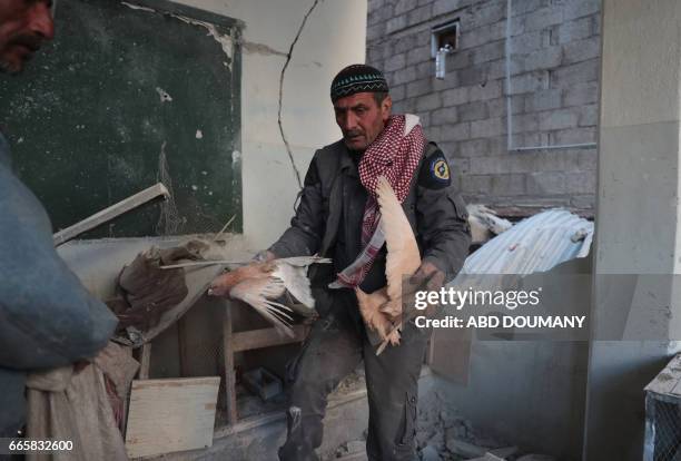 Bashir, a 55-year-old Syrian man, recovers pigeons from the rubble of a place he used to keep them following a reported air strike by government...