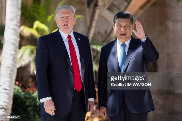 Chinese President Xi Jinping waves to the press as he walks with US President Donald Trump at the Mar-a-Lago estate in West Palm Beach, Florida,...