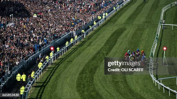 Racegoers watch the Doom Bar Sefton Novices' Hurdle Race on Ladies Day of the Grand National Festival horse race meeting at Aintree Racecourse in...