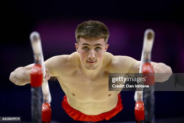 Sam Oldham of Great Britain takes part in a practice session on the parallel bars during previews to the iPro Sport World Cup of Gymnastics at The O2...