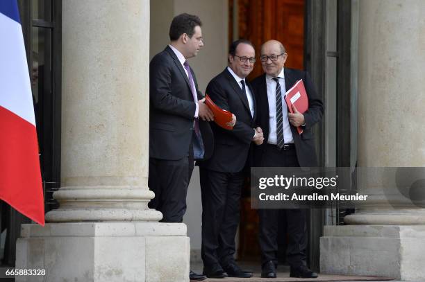 French President Francois Hollande shakes hands with French Minister of Interior, Matthias Fekl and French Minister of Defense Jean-Yves Le Drian as...