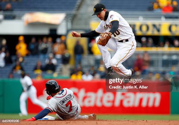 Jordy Mercer of the Pittsburgh Pirates records an out at second in the eighth inning against Dansby Swanson of the Atlanta Braves on Opening Day at...