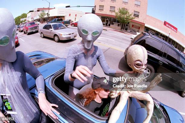 Groups dressed as aliens ride through downtown Roswell, New Mexico July 1, 2000 as they participate in the annual UFO Encounter, which runs through...