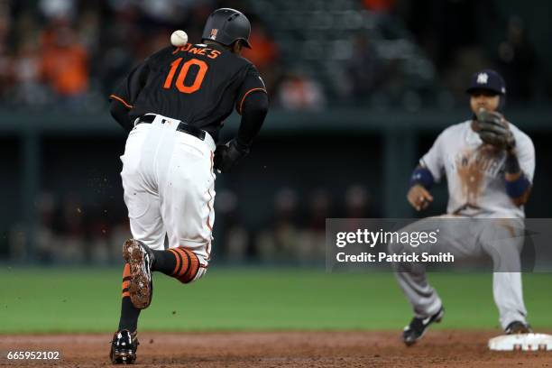 Adam Jones of the Baltimore Orioles is hit with a throw by third baseman Chase Headley of the New York Yankees as he attempts to tag up during the...