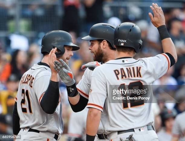 Brandon Belt of the San Francisco Giants, center, is congratulated, by Conor Gillaspie, and Joe Panik after hitting a Grand slam during the sixth...