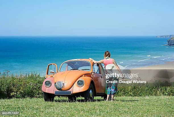 vw beetle and surfer. - blue capri pants stock pictures, royalty-free photos & images
