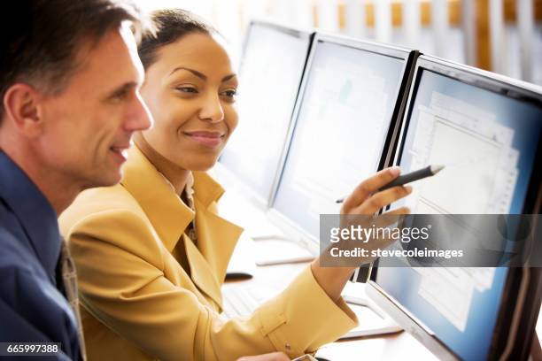 business woman with co-workers - two people at computer stock pictures, royalty-free photos & images